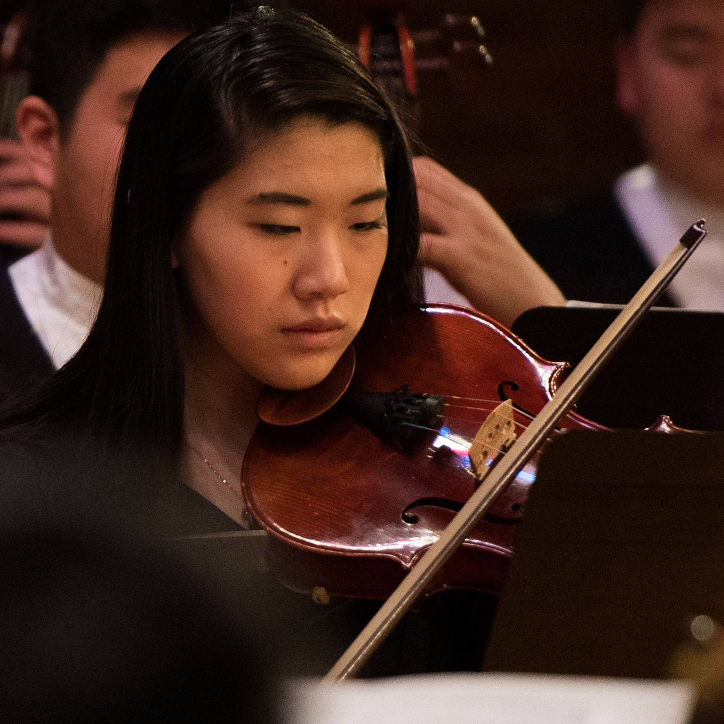 a woman playing a violin in an orchestra