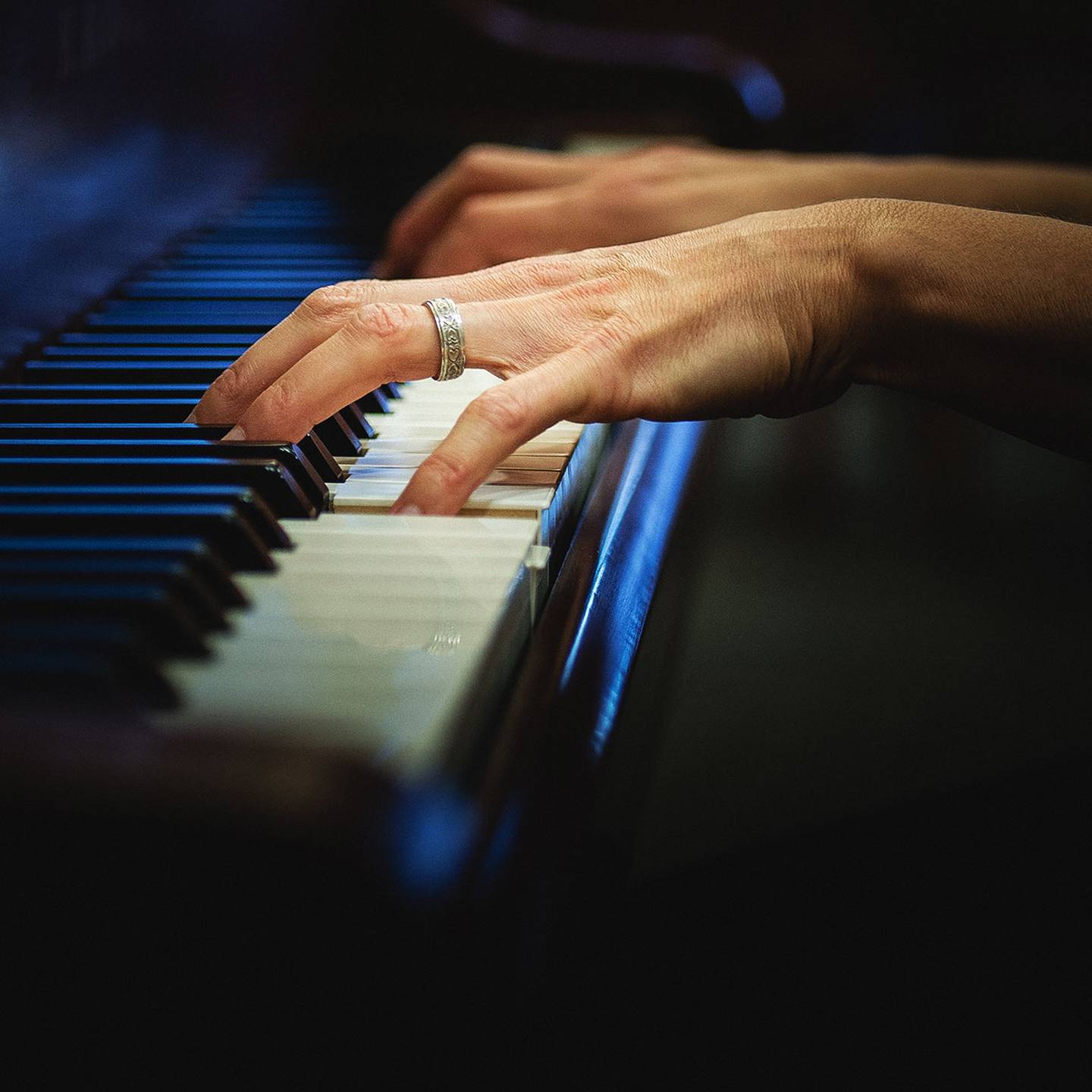 a close up of a piano keyboard and a person playing it