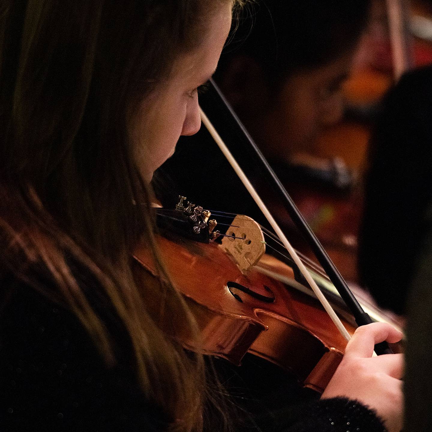 a close up of a woman playing a violin