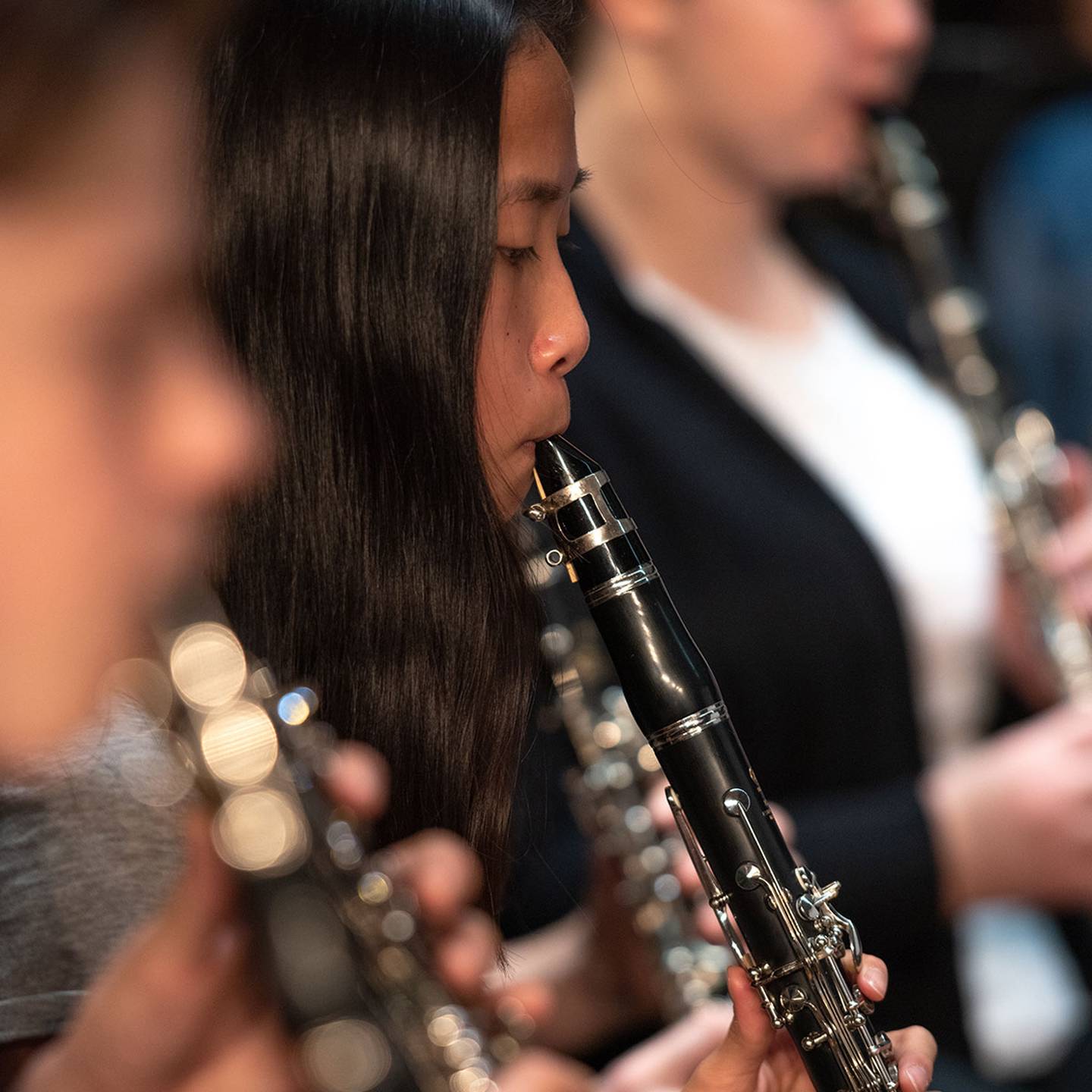a close up of a woman playing a clarinet