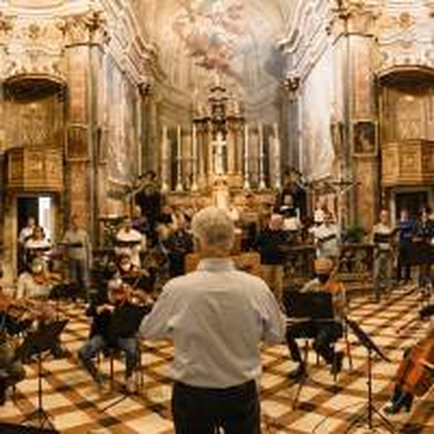 people sitting on chairs inside building playing instruments