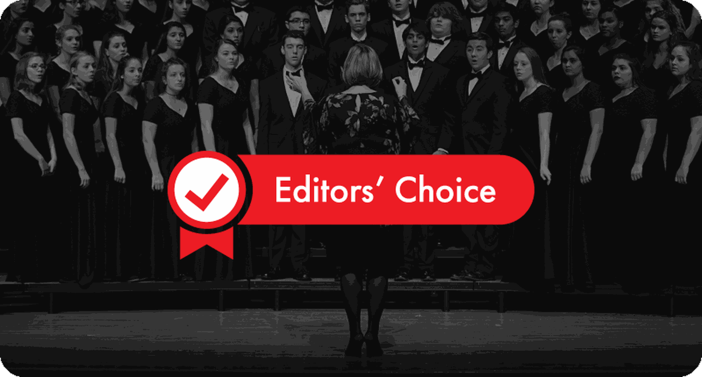 School choir on stage in formal attire.