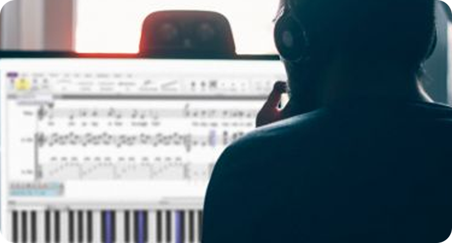 man sitting in front of computer looking at sheet music software